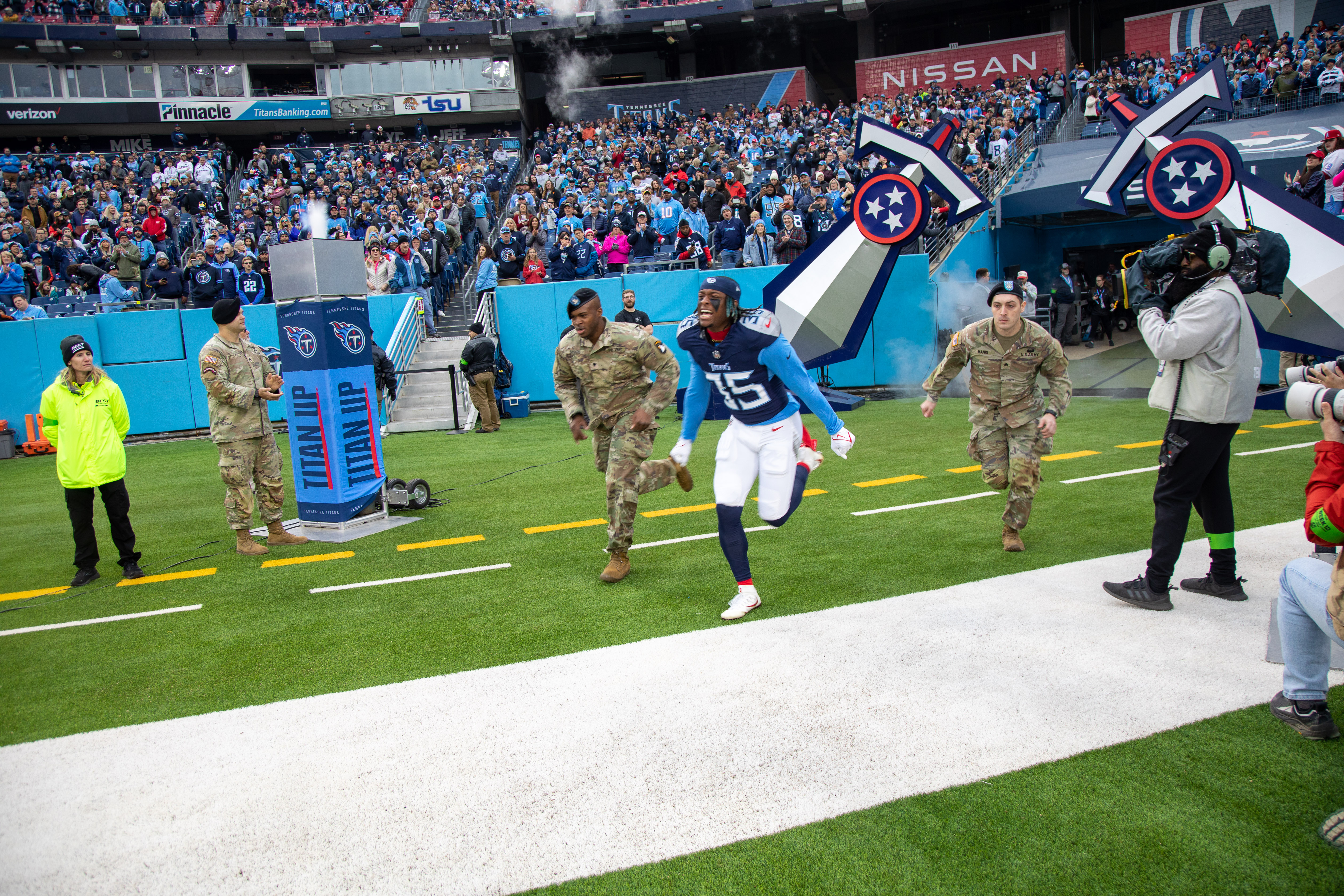 Titans players entering the field with Fort Campbell soldiers at Nissan Stadium in 2023