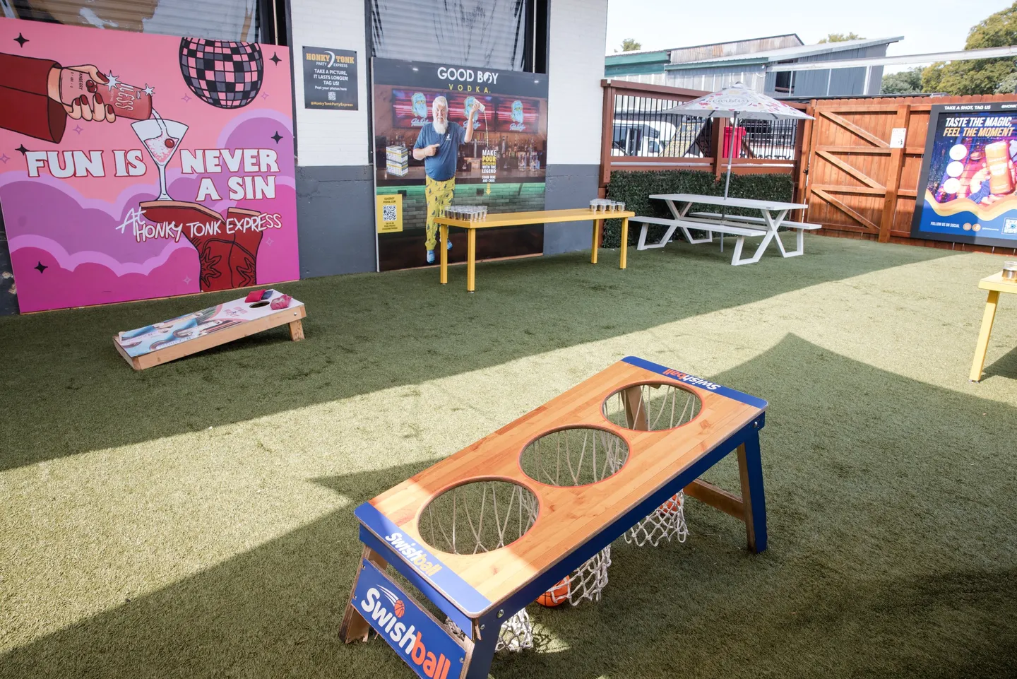 Cornhole boards beside the mural walls at Honky Tonk Hideaway