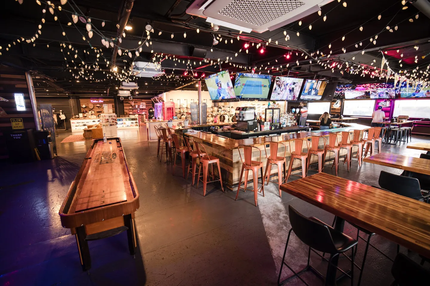 The Main Bar at Honky Tonk Hideaway, with long tables, bar seating and TVs