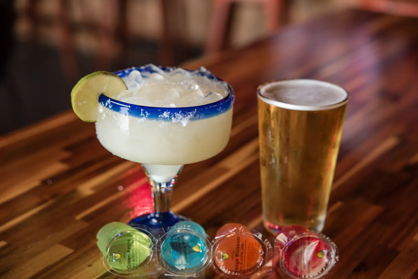 A margarita, beer and colorful shots on the bar at Honky Tonk Hideaway