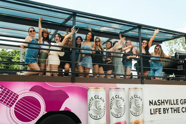 Guests aboard an open-air party bus outside Honky Tonk Hideaway